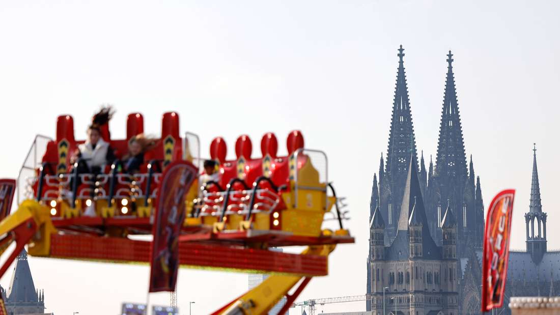Ein Fahrtgeschäft auf der Deutzer Kirmes, im Hintergrund der Kölner Dom